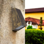 Applique murale extérieure en métal noir et doré, forme triangulaire, diffuseur en verre orienté vers le bas