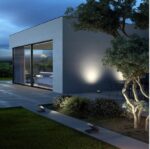 Applique murale extérieure grise émettant un faisceau lumineux dirigé contre le mur