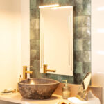 Applique miroir argentée linéaire installée au-dessus du miroir, finition métal