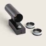 Applique murale cylindrique noire sur base rectangulaire, capteur PIR visible et deux optiques détachées