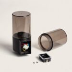 Applique murale extérieure démontée, base noire avec deux diffuseurs cylindriques fumés et connecteur électrique visible