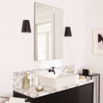 Applique murale noire conique en métal, fixée de chaque côté d'un miroir