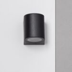 Applique murale noire cylindrique en métal mat, éclairage dirigé vers le bas