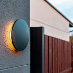 Applique murale ronde anthracite en aluminium, éclairage LED arrière créant un halo chaud