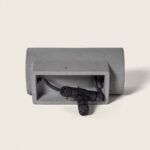 Applique murale extérieure en ciment gris, forme rectangulaire ouverte avec câble et connecteur visibles