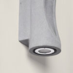 Applique murale extérieure en ciment gris, finition texturée, corps vertical avec spot LED orienté vers le bas