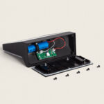 Applique murale extérieure noire ouverte avec batteries visibles, circuit imprimé et vis détachées