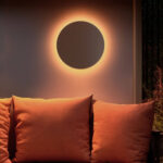 Applique murale ronde à halo lumineux chaud, disque foncé fixé au mur