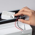 Applique murale extérieure blanche en aluminium, ouverte, montrant bloc d'alimentation LED et câbles rouges et noirs