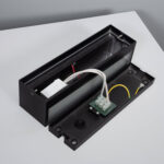 Applique murale rectangulaire noire double face démontée, boîtier métallique et connecteur de câblage visible