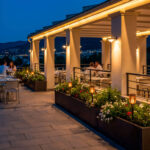 Applique murale extérieure linéaire à lumière chaude installée sous pergola sur terrasse