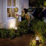 Balise extérieure sur pied noire cylindrique avec anneaux lumineux blancs, éclairage bas pour allée