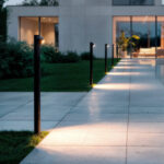 Balise extérieure cylindrique métal noir mat, éclairage LED dirigé vers le sol, montage au sol