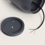 Balise sur pied gris foncé cylindrique avec base de fixation ronde et câbles électriques apparents