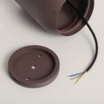 Balise sur pied couleur rouille, corps cylindrique ouvert avec câbles électriques et plaque de fixation ronde