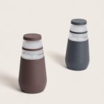 Balise sur pied LED, finition rouille et anthracite, corps cylindrique avec anneaux lumineux transparents.