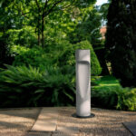 Balise extérieure cylindrique gris ciment avec fente d'éclairage sur socle au sol