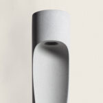 Balise extérieure gris ciment avec corps cylindrique et rainure incurvée, éclairage LED orienté vers le bas