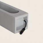 Balise extérieure en ciment gris rectangulaire avec connecteur électrique