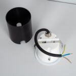 Balise murale encastrable blanche avec cylindre noir détachable et base ronde, câblage électrique apparent