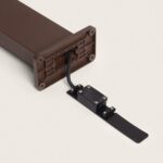 Balise sur pied couleur rouille, base rectangulaire avec câble apparent et support de fixation