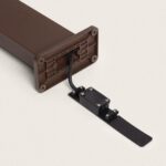 Balise sur pied marron rouille avec câble électrique apparent et plaque de fixation métallique