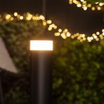 Balise sur pied cylindrique noire en métal avec diffuseur blanc éclairé