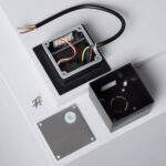 Balise encastrable carrée noire, boîtier métallique ouvert avec câblage, plaque de fixation et vis