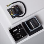 Balise encastrable extérieure noire démontée, boîtier de fixation carré, platine électrique, câblage et joint d'étanchéité