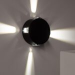 Applique murale LED ronde noire en saillie, faisceaux lumineux radiaux vers le mur