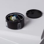 Balise murale circulaire noire en saillie, boîtier ouvert avec câblage visible et inserts translucides