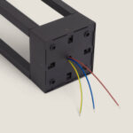 Balise sur pied noire, base carrée, câbles électriques apparents, structure métallique rectangulaire