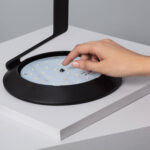 Balise LED ronde noire avec plateau à LED visible et détecteur central, finition mate