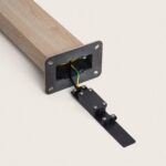 Balise sur pied brun clair avec plaque de fixation métallique et câblage de terre apparent