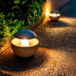 Balise sur pied en ciment beige avec dôme métallique sombre et éclairage LED blanc chaud pour allée