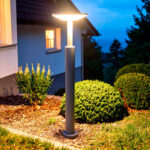 Balise sur pied noire en aluminium, finition mat, mât cylindrique avec diffuseur plat éclairant le jardin