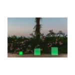 Cube LED vert translucide posé au sol, trois tailles visibles, forme cubique pour éclairage extérieur