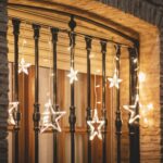 Guirlande LED étoile blanc chaud suspendue sur rambarde extérieure