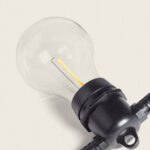 Ampoule filament LED E27 verre transparent sur douille noire de guirlande extérieure