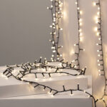 Guirlande LED câble noir ampoules blanc chaud, enroulée et suspendue