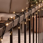 Guirlande LED extérieure câble noir ampoules blanc chaud espacées fixée sur rambarde