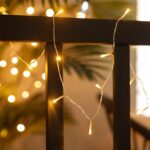 Guirlande LED solaire à petites LED blanches chaudes sur câble fin, suspendue à une rampe extérieure