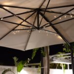 Guirlande LED extérieure, lumières blanc chaud sur fil transparent fixée sous un parasol