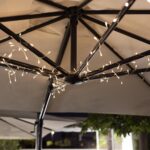 Guirlande LED blanc chaud sur fils fins, fixée aux baleines d'un parasol