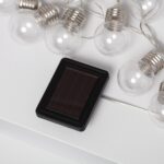 Guirlande LED solaire à ampoules rondes transparentes, câble blanc et petit panneau solaire rectangulaire