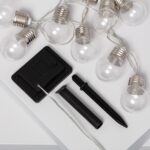 Guirlande LED solaire avec ampoules transparentes, douilles argentées, câble blanc et panneau solaire avec piquet