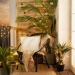 Guirlande d'ampoules LED à ampoules transparentes et lumière chaude, câbles noirs, suspendue parmi des plantes