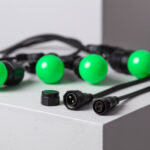 Guirlande LED avec ampoules sphériques vertes, câble noir et connecteurs visibles