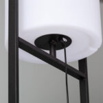Lampadaire sur pied métal noir avec abat-jour cylindrique blanc et câbles visibles