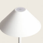 Lampadaire blanc à abat-jour conique, bouton tactile circulaire sur le sommet et tige fine